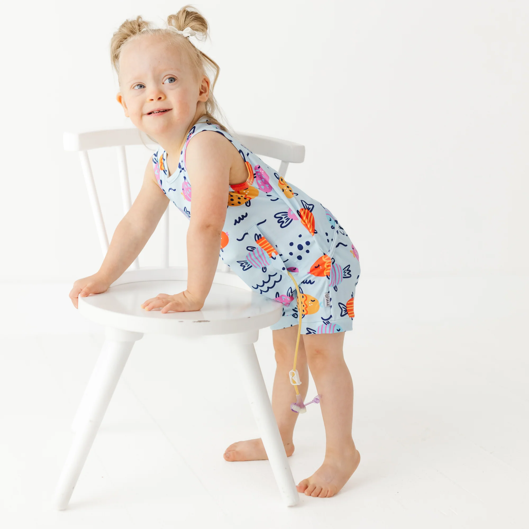 Girl wears fish patterned toddler romper